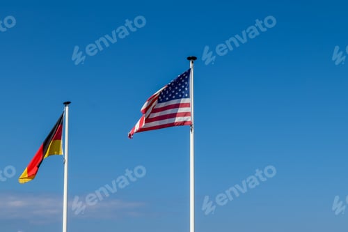 Preview: American flag and a German flag waving together in the air