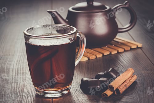 Preview: cup of tea with cinnamon sticks and teapot
