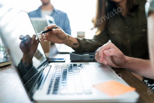 Preview: Colleagues Planning Over Laptop At Desk
