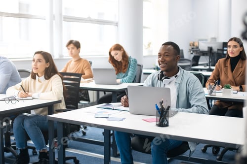 Preview: Group of international people using laptop listening to teacher