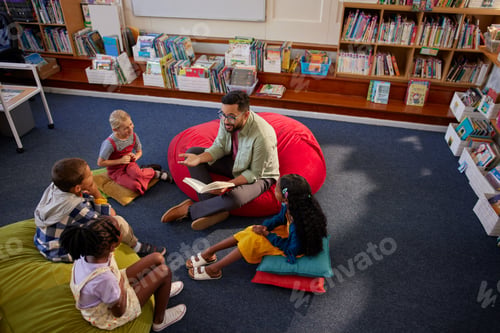 Preview: Friendly teacher reading a book to pupils during literature class