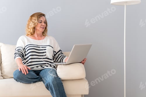 Preview: Woman Works on Laptop While Sitting on Couch