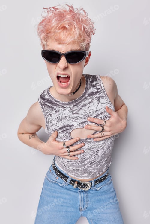 Preview: Vertical image of emotional pink haired man exxclaims loudly keeps hands on chest wears sunglasses