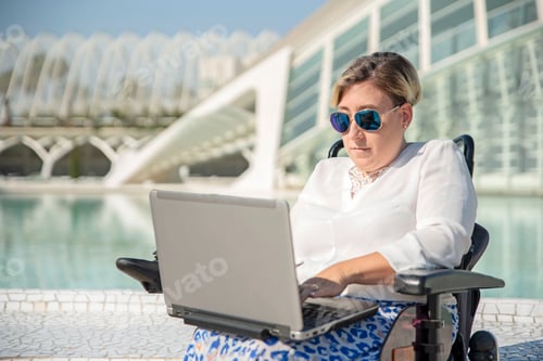 Preview: Woman Uses Laptop While Sitting in Wheelchair Outdoors