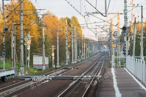 Preview: Train station with railway tracks, autumn season. Perspective of electrified high-speed railroad