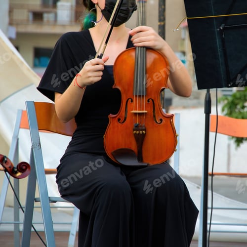 Preview: Closeup shot of a female musician with the violin in an orchestra