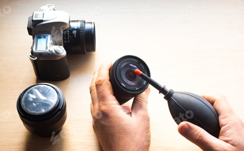 Preview: Closeup shot of male hands cleaning a photographic lens