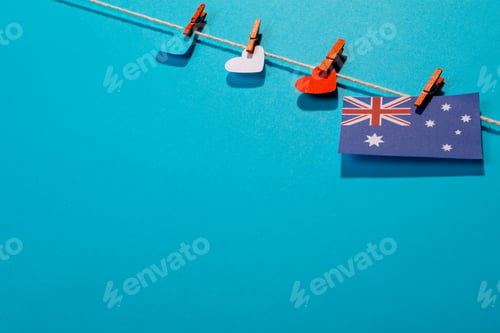 Preview: Australia flag with heart shaped papers on clothesline isolated on blue background with copy space