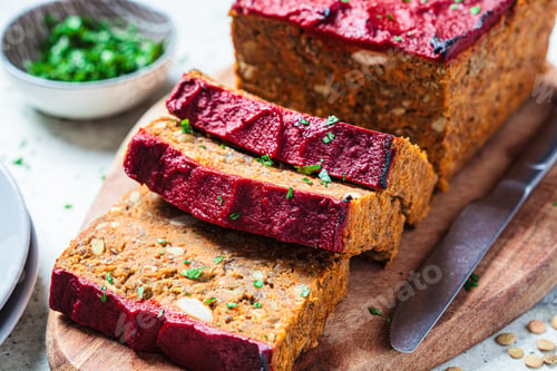 Preview: Lentil vegan meat oaf sliced on wooden board. Christmas recipe.