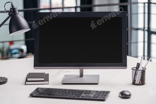 Preview: computer monitor with blank screen and stationery at workplace in modern office