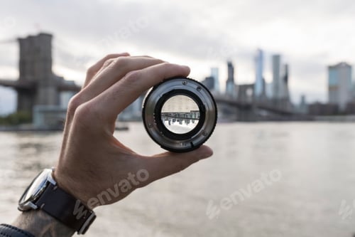 Preview: Hand holding a lens against New York City skyline