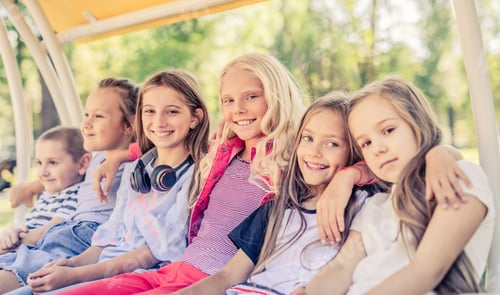 Preview: Smiling Children Sitting Together on a Swing Bench