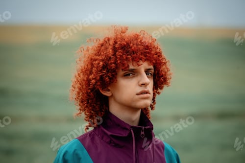 Preview: young guy with red curly hair in 80s sports suit on the field