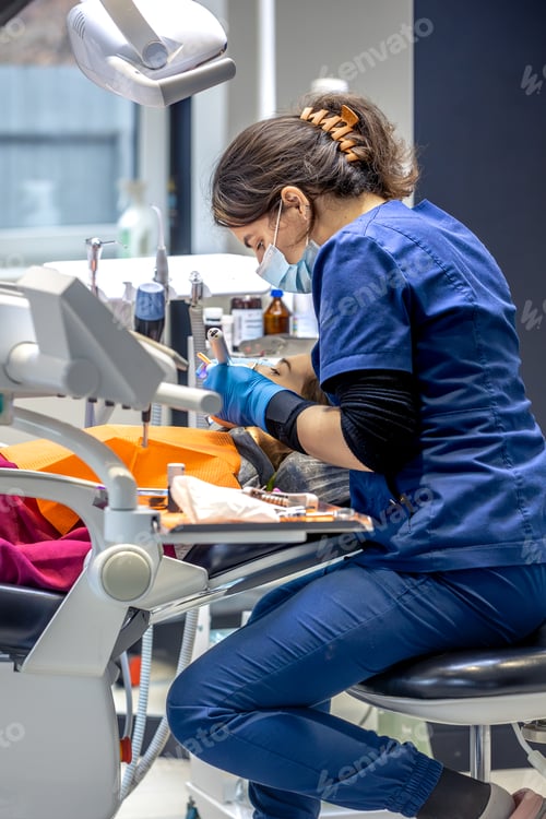 Preview: Young female dentist in dental office. Dentist at work. Dental treatment concept.