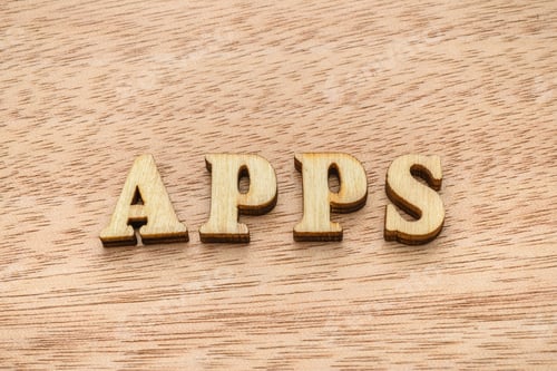 Preview: Wooden letter spelling the word APPS on wooden background.