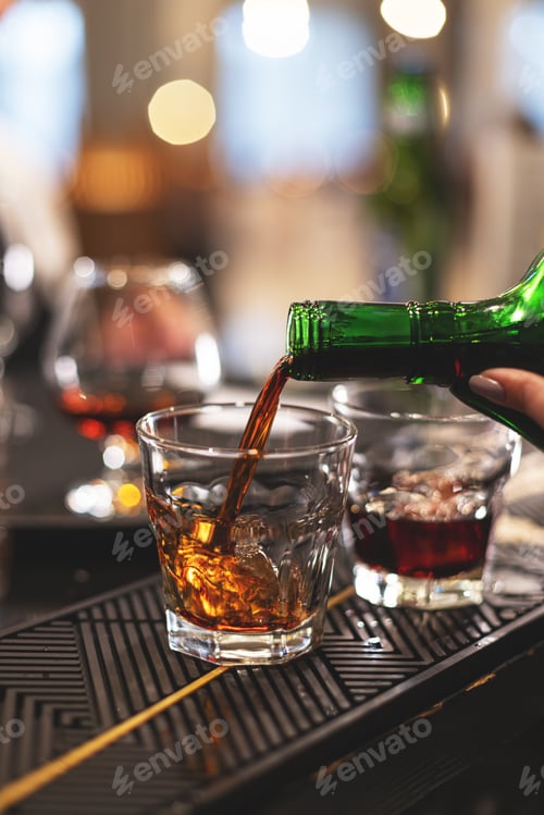 Preview: Close-up of a hand pouring amber whiskey