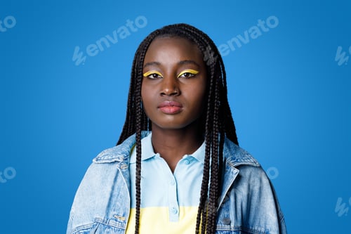 Preview: Cool stylish young black woman posing on blue