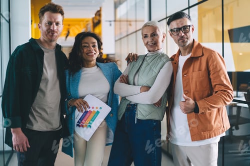 Preview: happy diverse professional colleagues smiling at camera together in office interior