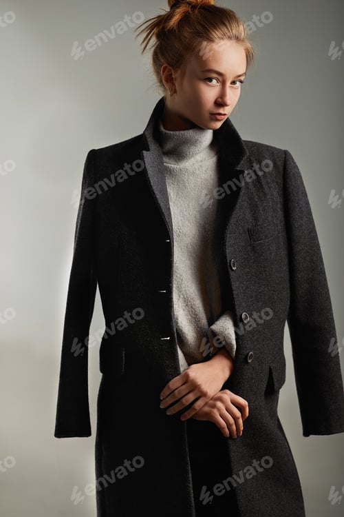 Preview: Portrait fashion model woman gray coat style pose on color background in studio