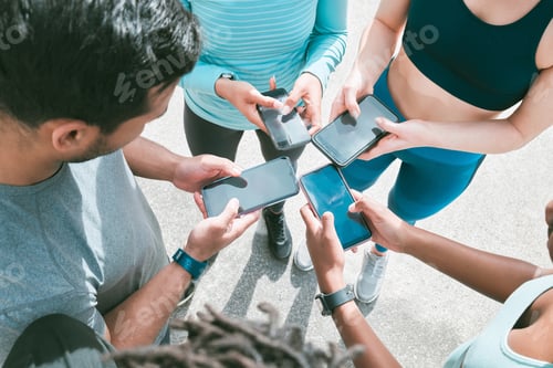 Preview: Closeup of diverse group of sporty people from above using cellphones with blank screens in synchro