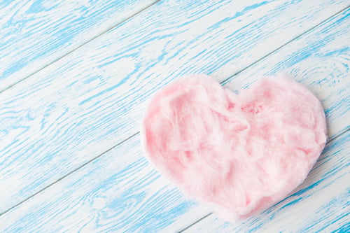 Preview: Sweet cotton candy in heart shape on blue wooden background. Copy space