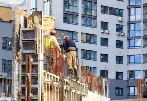 Preview: Low angle shot of workers pouring concrete in the formwork of the walls on a new building