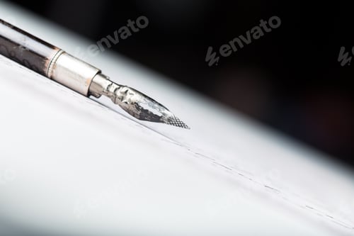 Preview: Close look at a fountain pen nib resting on a white surface with soft lighting