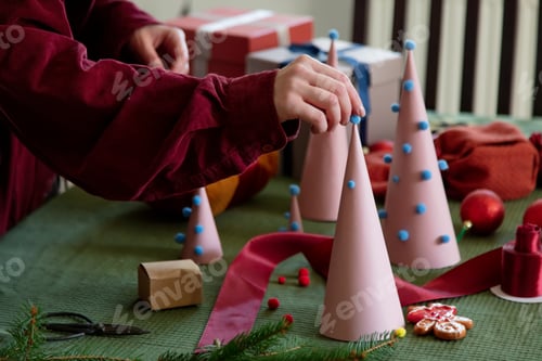 Preview: Woman prepearing paper Christmas tree in ecological way at home