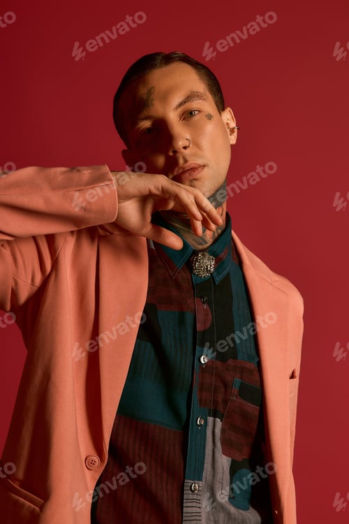 Preview: Handsome stylish man showcasing modern fashion against a bold backdrop