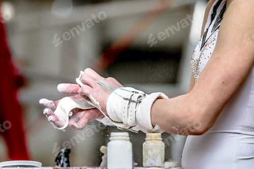Preview: girl gymnast prepares his hands with chalk