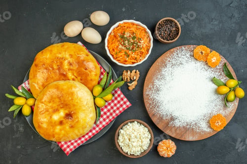 Preview: Above view of delicous fresh baked pastries and cheese peppers eggs flour tangerines on the wooden