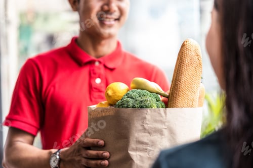 Preview: Asian deliver man worker in red color uniform handling bag of food.