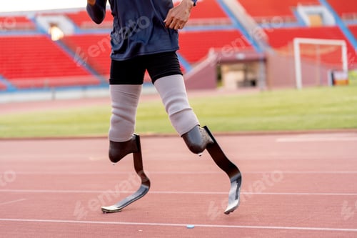 Preview: Close up sport man athlete prosthesis legs stand and warm up legs on track in the stadium.