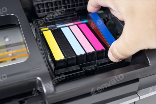 Preview: Human hand changing a blue ink cartridge of a multicolor inkjet printer