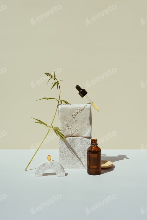 Preview: CBD oil in pipette and an open bottle on podium with a leaf of marijuana, hemp