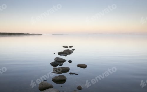 Preview: Beautiful scenery of the stones on the shore of the calm sea at dusk