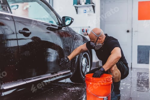 Preview: Service man washing car before detailing in workshop.
