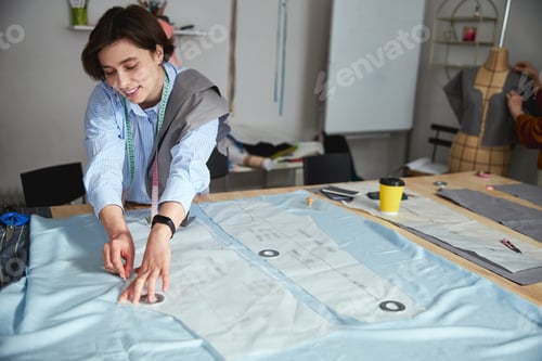 Preview: Dressmaker painting lines on fabric with a smile