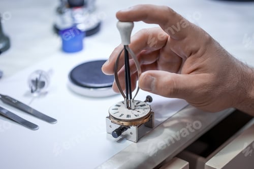 Preview: Closeup shot of a craftsman fixing gears on a clock
