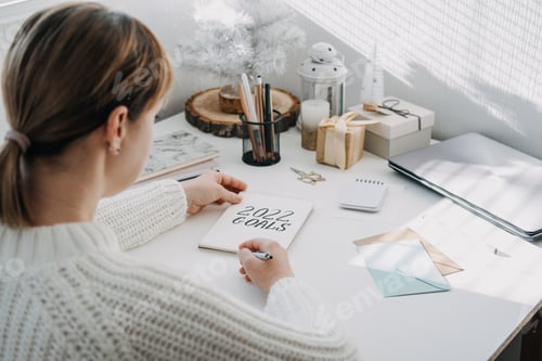 Visualização: Metas de 2022, resolução de ano novo. Mulher de suéter branco escrevendo texto: metas de 2022