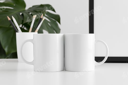 Preview: Two mugs mockup with workspace accessories and a monstera plant.