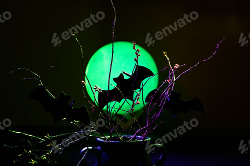Preview: Cutout bats attached to branches against a moon