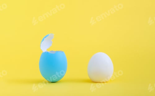 Preview: Boiled egg and a blue eggshell isolated on a yellow background