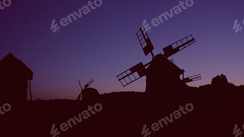 Preview: Windmills in the countryside at sunset.