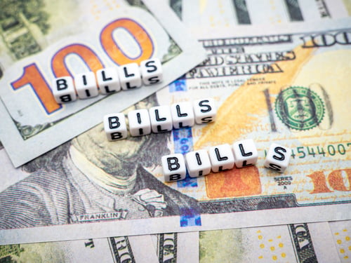 Preview: Words "bills" made of white blocks on dollar banknotes