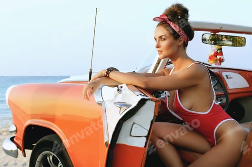Preview: Sexy woman in red swimsuit and retro cabriolet car