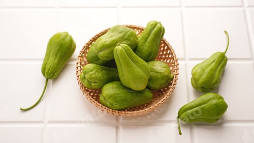 Preview: A pile of green chayote squash on bamboo plate
