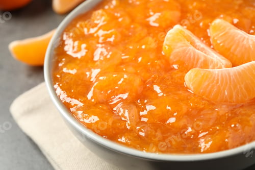 Preview: Tasty tangerine jam in bowl on table, closeup