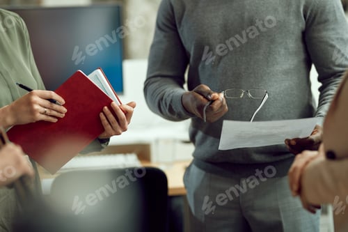 Preview: Unrecognizable business team going through reports during meeting in the office.