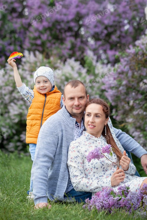 Preview: Happy mother, father and little son having picnic at summer park. Young parents with boy